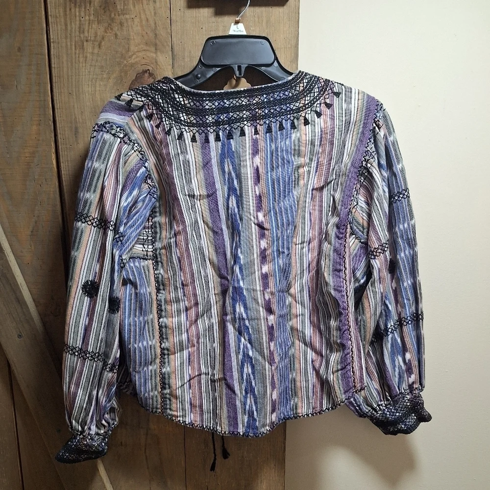 A Free People long sleeve blouse with string ties in the front in a size small.